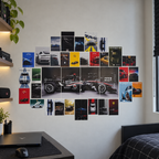 A wall collage of various automotive posters and stickers arranged in a geometric pattern on a light gray wall in a modern bedroom setting.